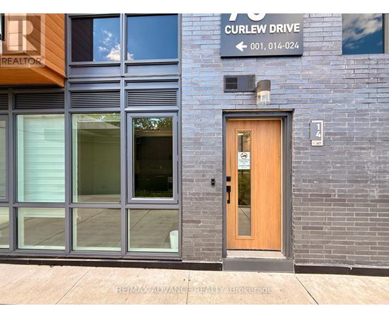 A building with a wooden door and a sign that says Curlew Drive.