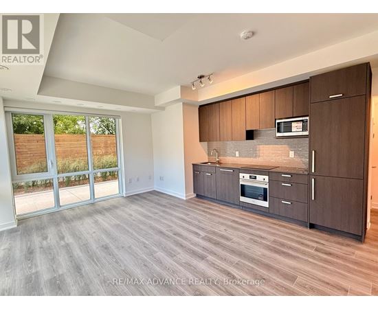 A spacious kitchen with dark wood cabinets and a stainless steel oven.