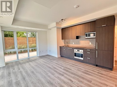 A spacious kitchen with dark wood cabinets and a stainless steel oven.