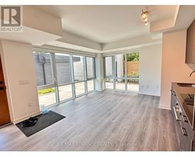 A spacious living room with a sliding glass door leading to a backyard.