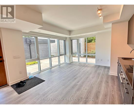 A spacious living room with a sliding glass door leading to a backyard.