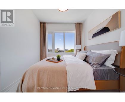 A bedroom with a large bed and a view of the city through the window.