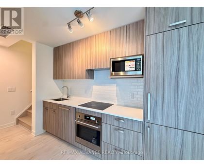 A modern kitchen with wooden cabinets and stainless steel appliances.