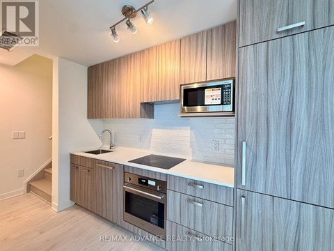 A modern kitchen with wooden cabinets and stainless steel appliances.