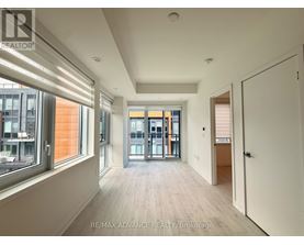 A spacious room with a view of the city through large windows.