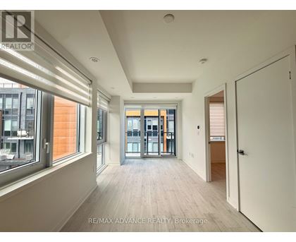 A spacious room with a view of the city through large windows.