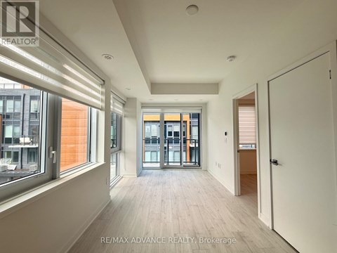A spacious room with a view of the city through large windows.