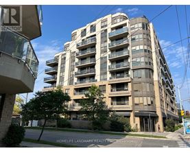 A tall apartment building with balconies and a sign that says "REALTOR" on the left side.