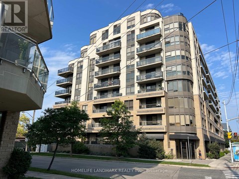 A tall apartment building with balconies and a sign that says "REALTOR" on the left side.