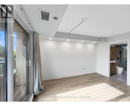 A spacious room with a slanted ceiling and a large mirror on the wall.