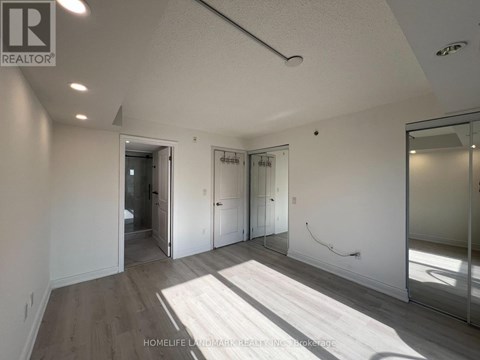A spacious room with a slanted ceiling and a large mirror on the wall.