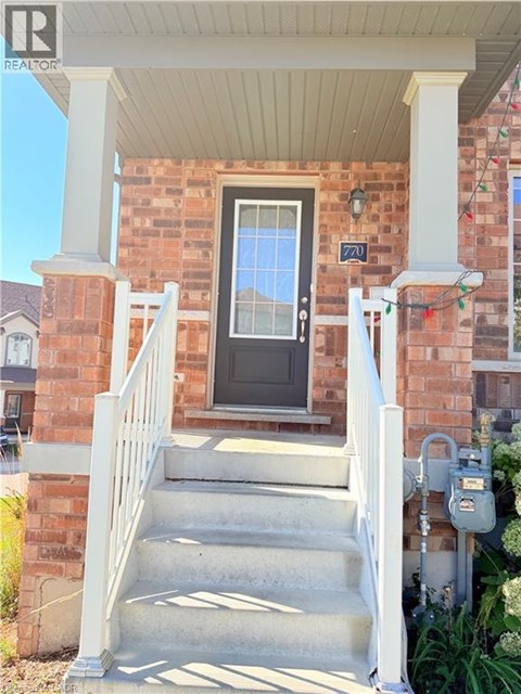 A house with a black door and a white railing.