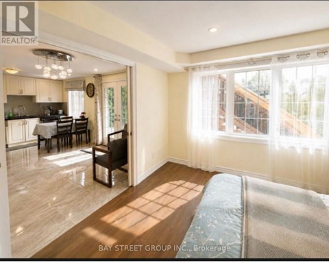 A well-lit living room with a dining area in the background.
