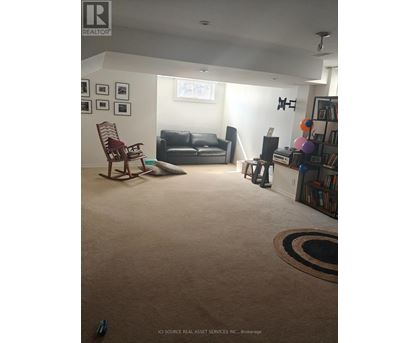 A living room with a couch, chair, and rug.