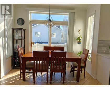 A dining room with a table and chairs.