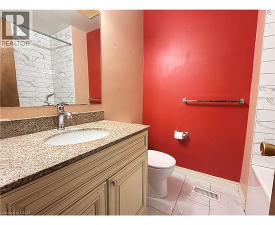 A bathroom with a red wall and a white toilet.