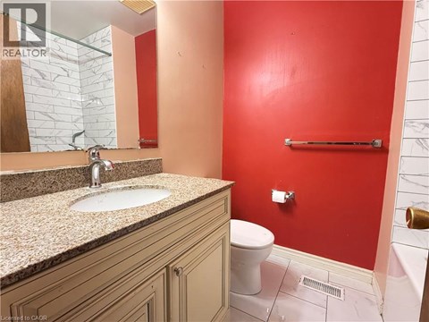 A bathroom with a red wall and a white toilet.