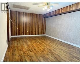 A room with wooden walls and floor and a ceiling fan.