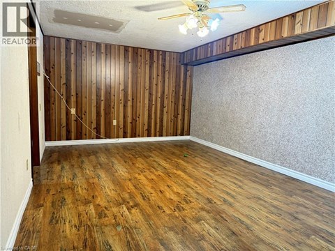 A room with wooden walls and floor and a ceiling fan.