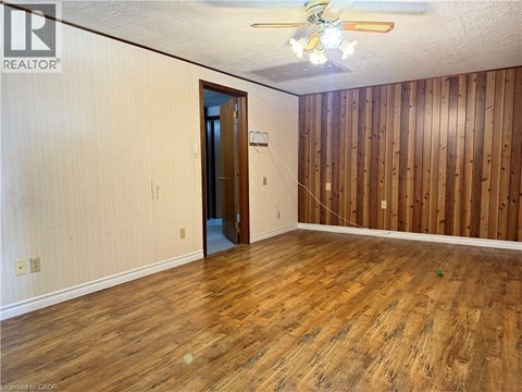 A room with wooden floors and a ceiling fan.