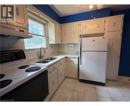 A kitchen with a white refrigerator and black stove top oven.