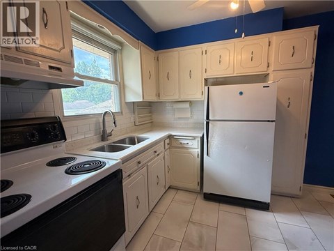 A kitchen with a white refrigerator and black stove top oven.