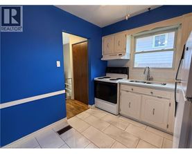 A kitchen with blue walls and white cabinets.