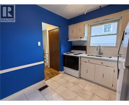 A kitchen with blue walls and white cabinets.
