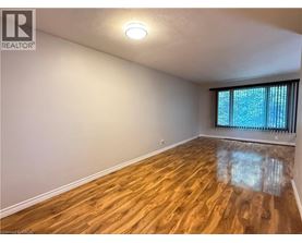 A room with wooden flooring and a window with blinds.