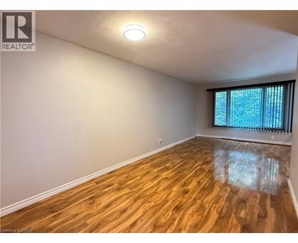 A room with wooden flooring and a window with blinds.