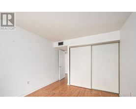 A white room with a sliding door and a small white door in the background.