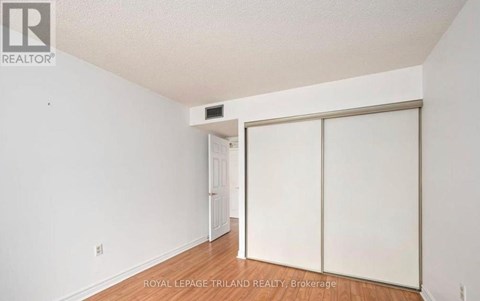 A white room with a sliding door and a small white door in the background.