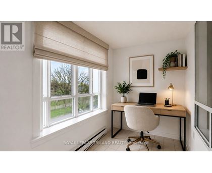 A well-lit home office with a laptop, chair, and plants.