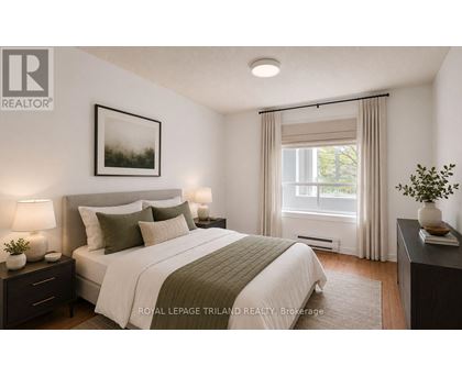 A bedroom with a large bed and a window with curtains.