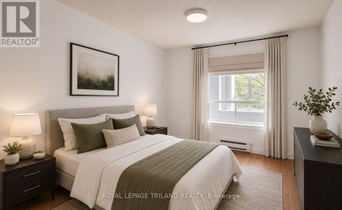 A bedroom with a large bed and a window with curtains.