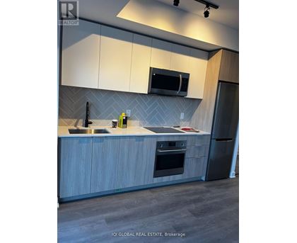 A modern kitchen with a sink, microwave, and refrigerator.