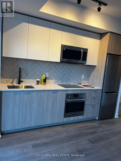 A modern kitchen with a sink, microwave, and refrigerator.