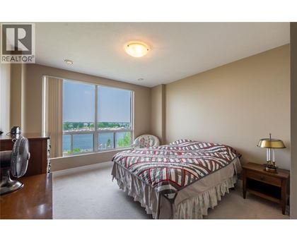 A bedroom with a large bed and a fan.