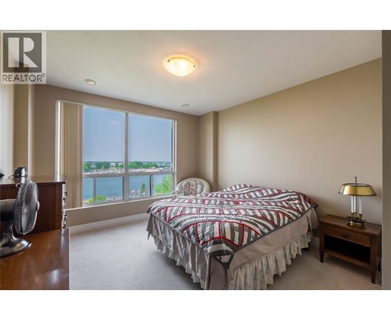 A bedroom with a large bed and a fan.