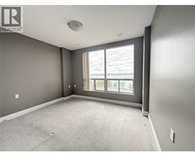 A spacious room with grey walls and a large window.