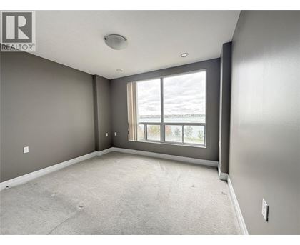 A spacious room with grey walls and a large window.