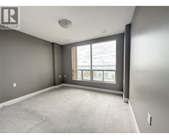 A spacious room with grey walls and a large window.