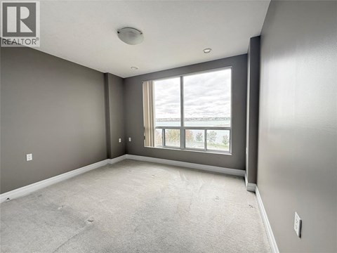 A spacious room with grey walls and a large window.
