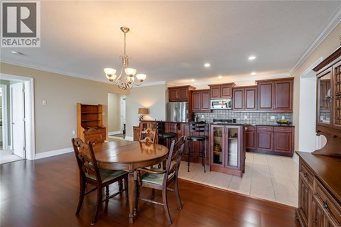 A well-lit kitchen with a dining table and chairs.