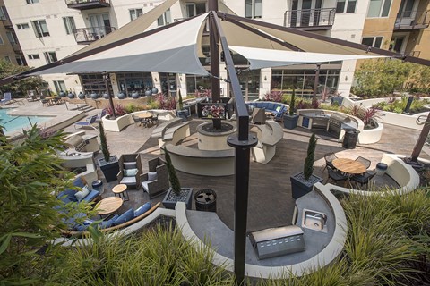 A large white tent is set up in the middle of a courtyard with a pool and seating area.