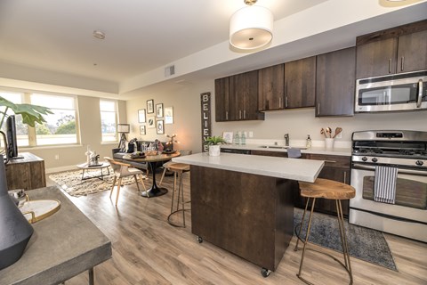 A modern kitchen with dark wood cabinets and white appliances.