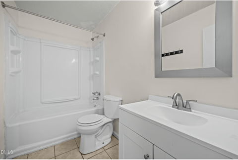 A white bathroom with a toilet, sink, and bathtub.