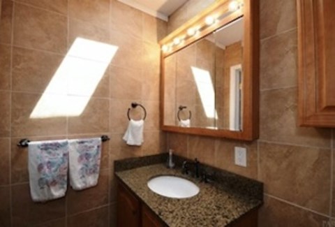 A bathroom with a sink, mirror, and towel.