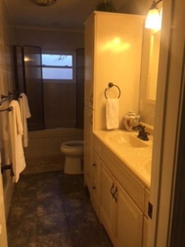 A bathroom with a toilet, sink, and shower.