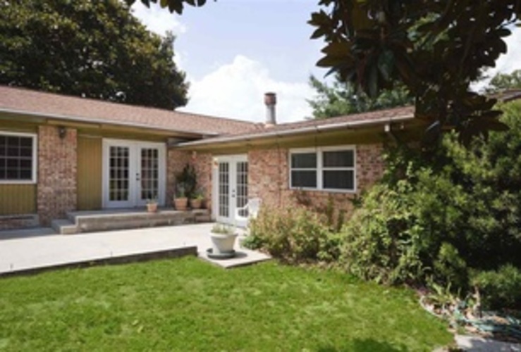 A house with a white fence and a green lawn.